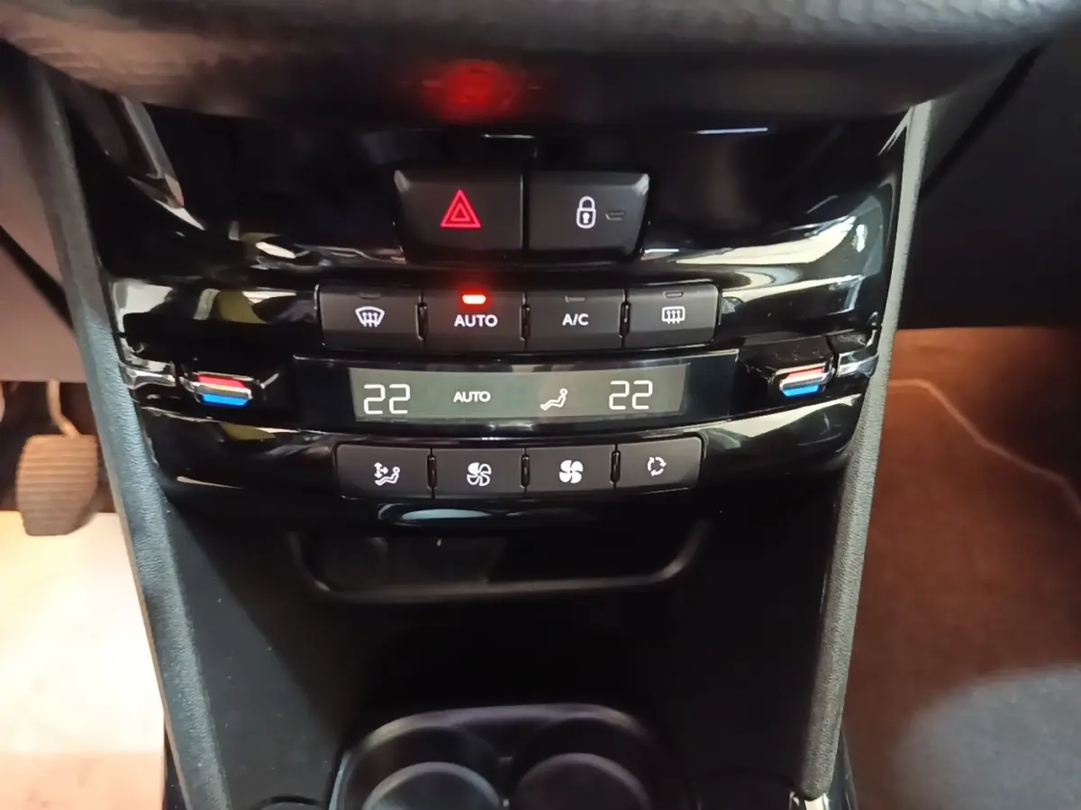 Vue rapprochée de la console centrale noire du Peugeot 2008 2019, avec commandes climatisation digitale affichant 22°C.