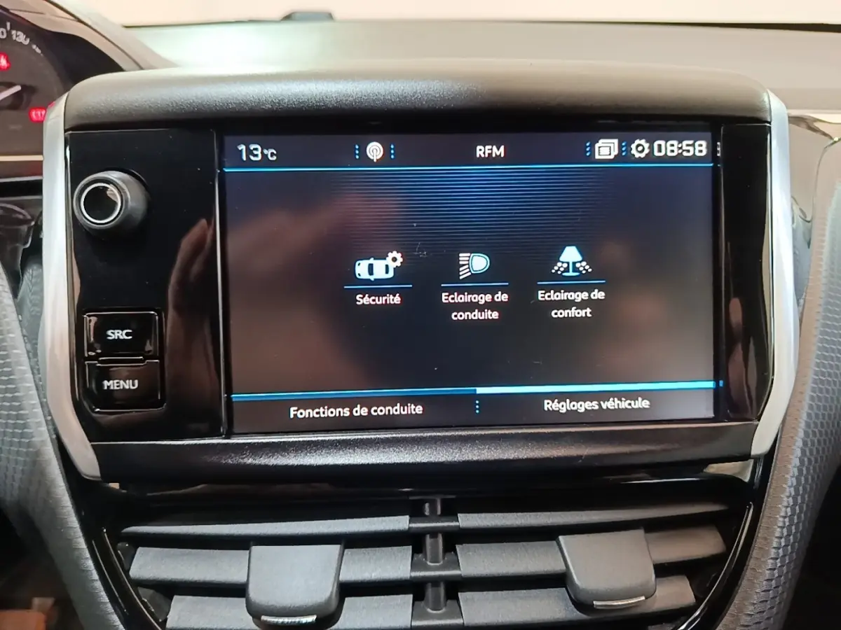 Écran tactile central affichant les réglages de sécurité et éclairage dans l’habitacle d’une Peugeot 2008 noire.