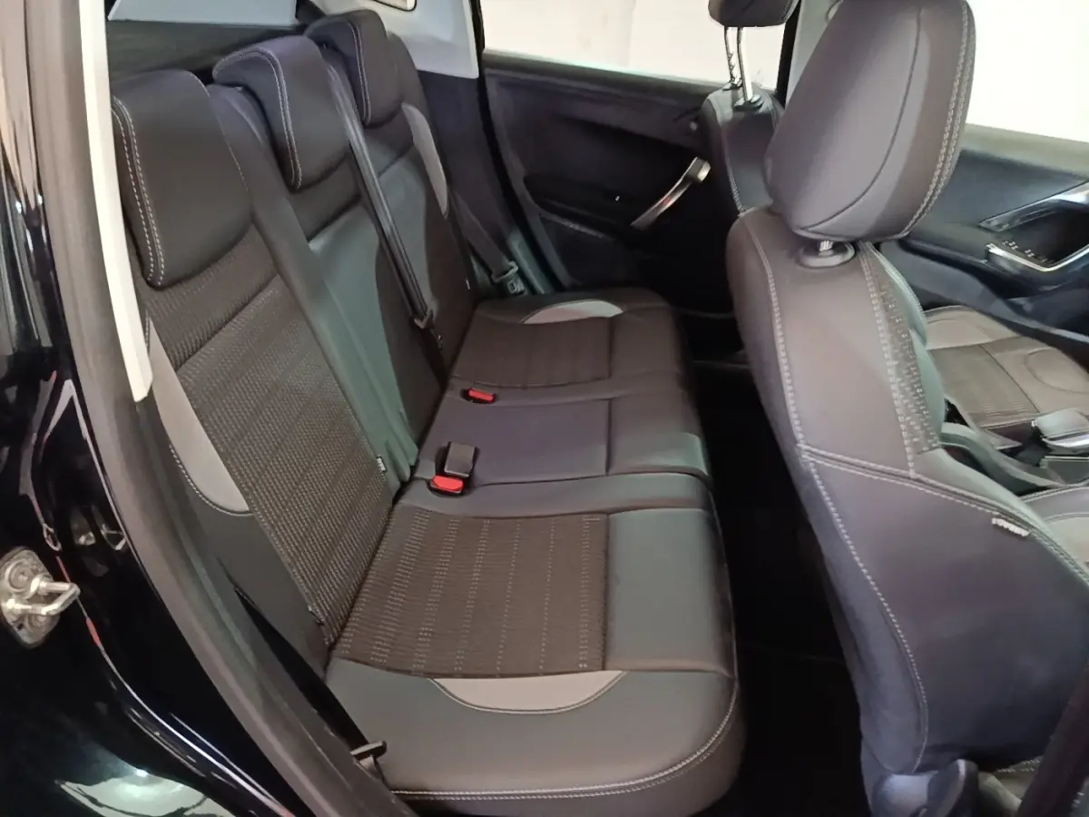 Vue intérieure côté gauche montrant la banquette arrière noire et les sièges avant du Peugeot 2008 Puretech 130 S&S Allure Business 2019.