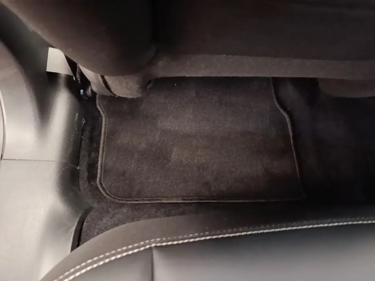 Vue rapprochée du tapis de sol noir et de la moquette sous le siège arrière côté droit d’un Peugeot 2008 noir.