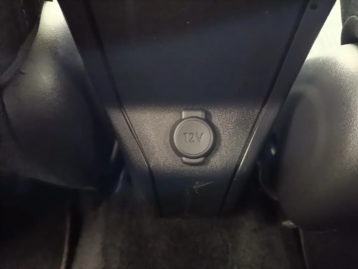 Prise 12V en gros plan dans l'habitacle noir du Peugeot 2008 Puretech 130 S&S Allure Business 2019.