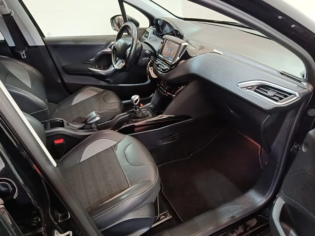 Intérieur avant droit du Peugeot 2008 noir, montrant sièges cuir, tableau de bord avec écran tactile et volant multifonctions.