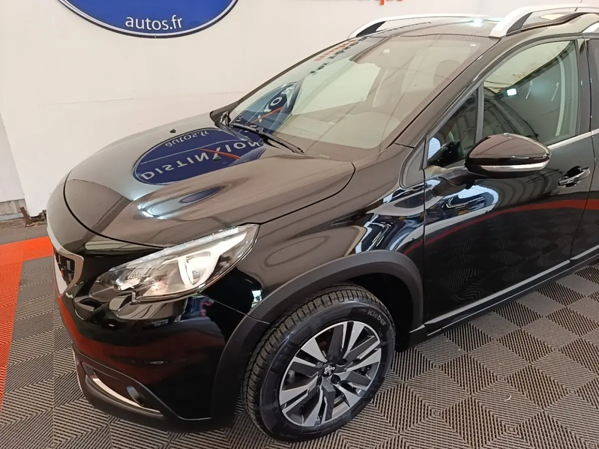Vue 3/4 avant droit d’un Peugeot 2008 noir avec jantes alliage et rétroviseurs noirs brillants.