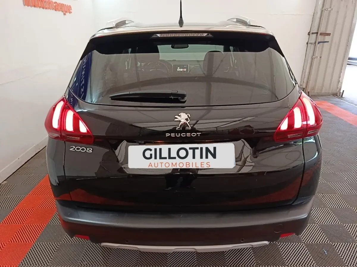 Vue arrière d’un Peugeot 2008 noir avec feux LED allumés dans un garage intérieur.