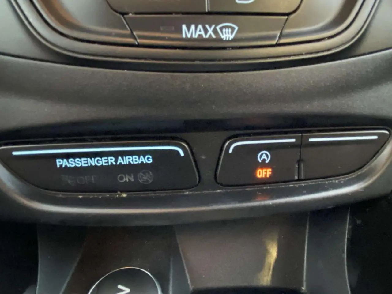 Gros plan sur les commandes du tableau de bord du Ford B-MAX blanc, affichant l'airbag passager et le système Stop & Start désactivé.