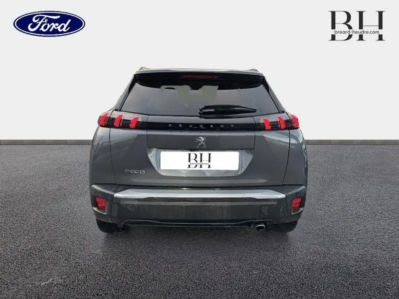 Vue arrière d'un Peugeot 2008 gris Artense 2021 avec feux LED et barres de toit visibles.
