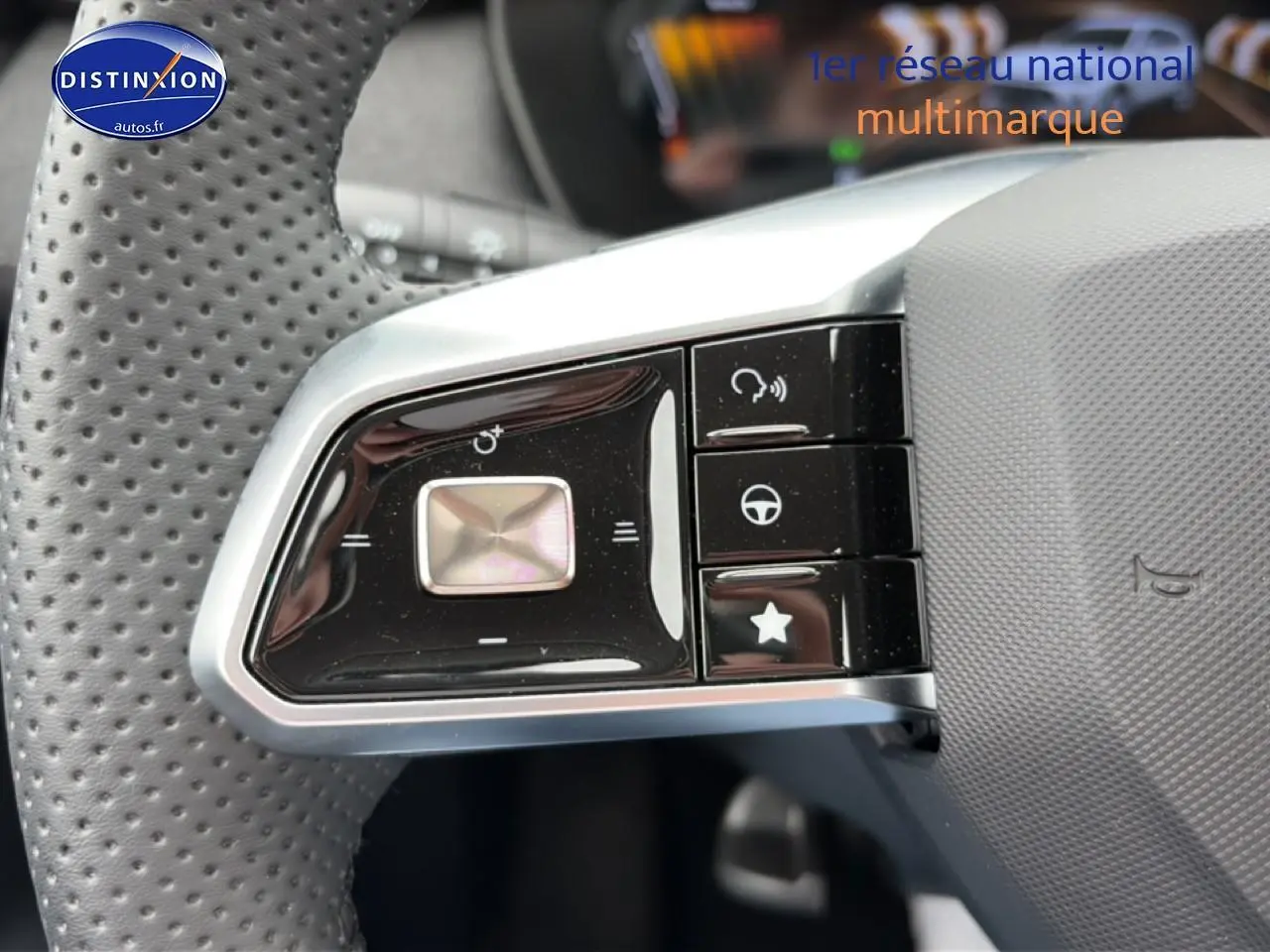 Gros plan sur les commandes gauche du volant perforé du MG ZS Hybrid blanc 2026, avec boutons multifonctions noirs.