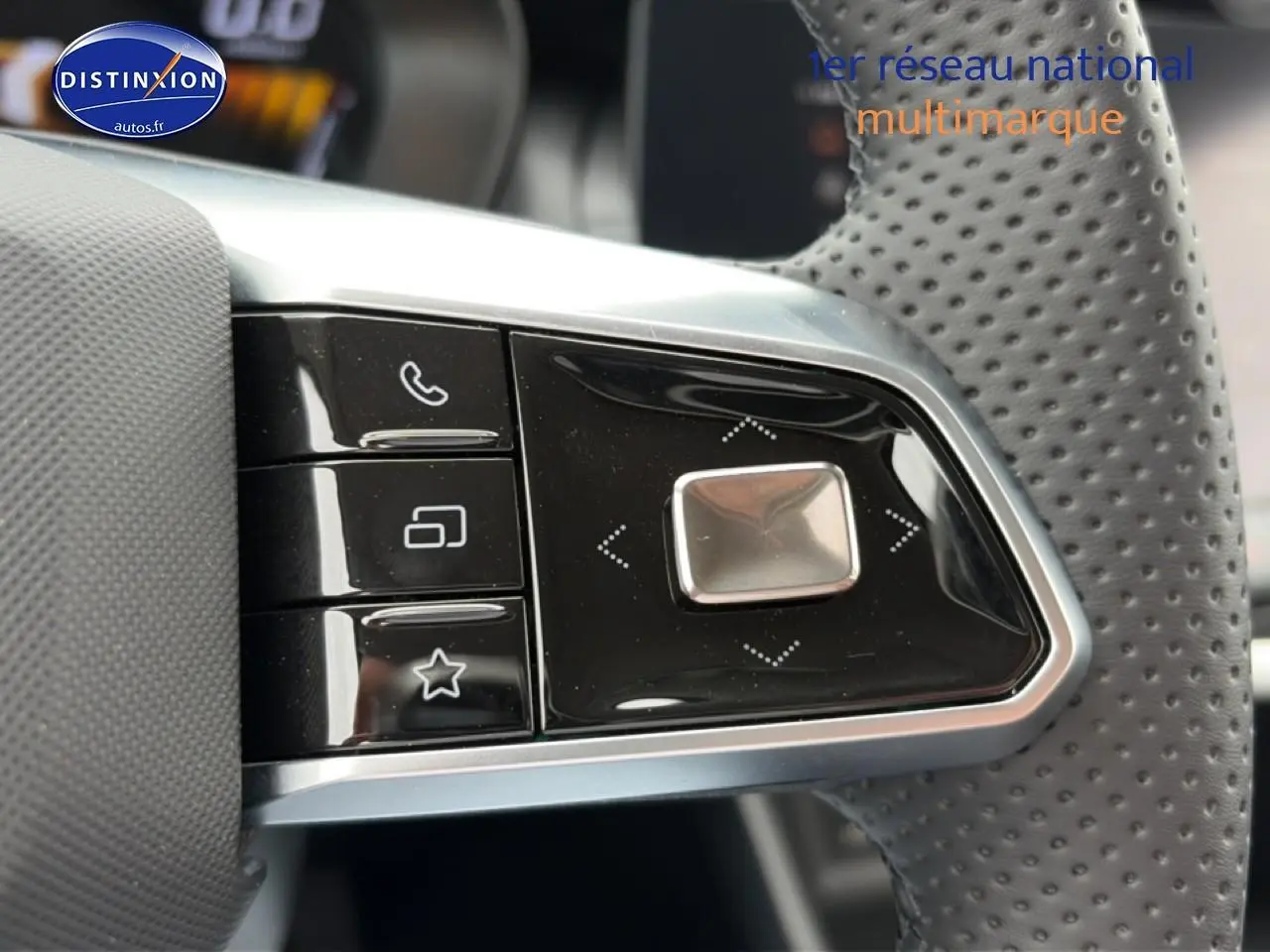 Gros plan sur les commandes multifonctions noires à gauche du volant perforé du MG ZS Hybrid blanc 2026.