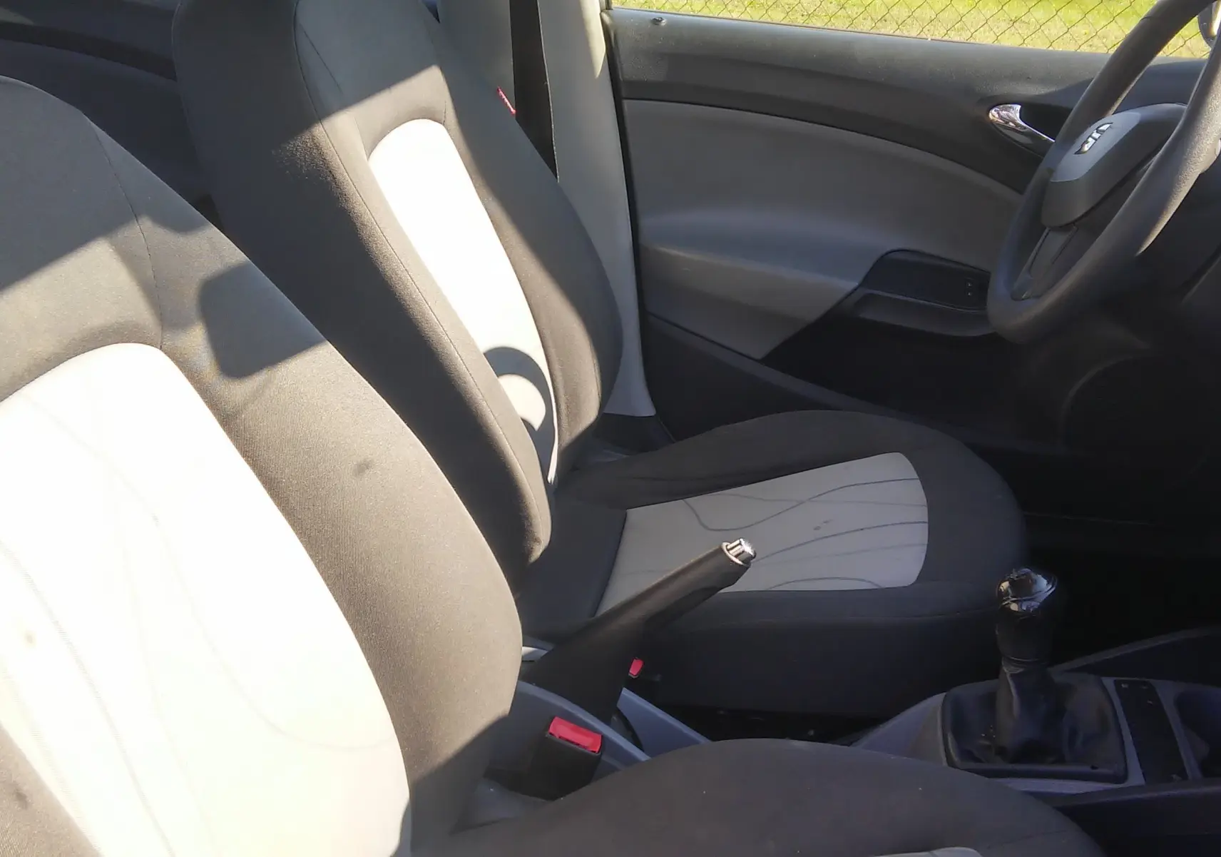 Intérieur de la SEAT Ibiza Business 2015 vu côté droit, sièges tissu noir et gris avec levier de vitesse manuel.