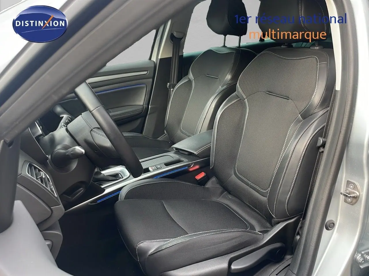 Intérieur de la Renault Mégane Break 2024 en gris Highland Metal, vue côté conducteur sur les sièges en cuir noir et console centrale.