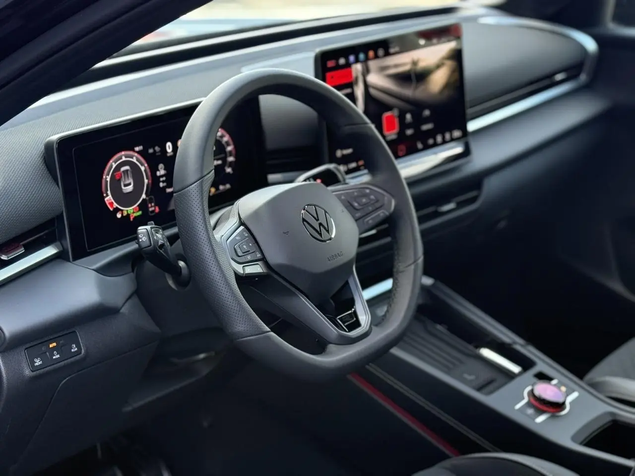 Vue intérieure du tableau de bord et volant noir du Volkswagen T-Roc 1.5 eTSI Hybrid avec écran digital et console centrale moderne.