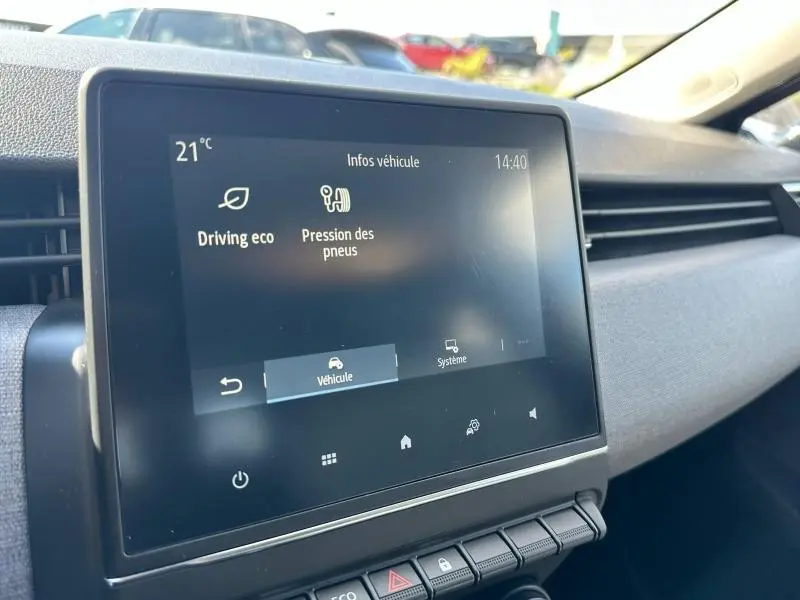 Écran tactile central affichant les infos véhicule dans l’habitacle gris d’une Renault Clio 2025, vue de côté droit.