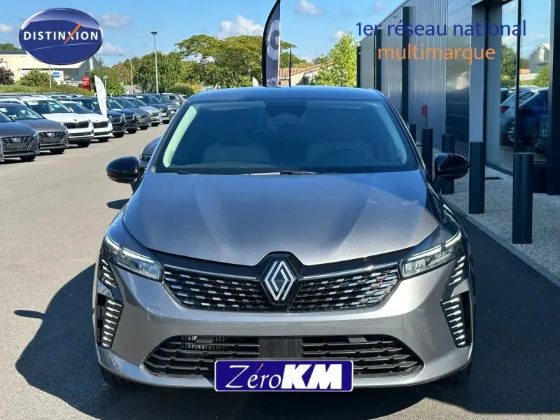 Vue avant d'une Renault Clio 2025 gris Rafale avec calandre noire et feux LED distinctifs allumés.