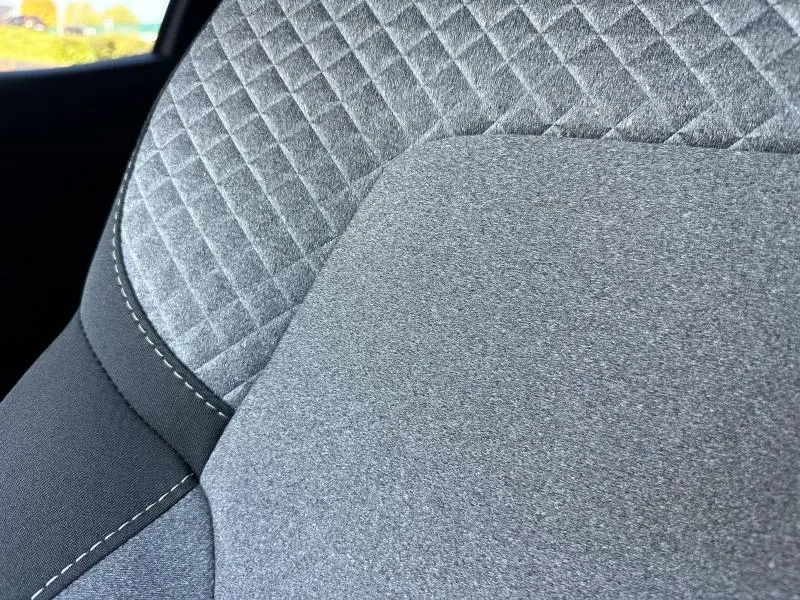 Détail du tissu gris à motif 3D sur le siège avant de la Renault Clio 2025, version Evolution.