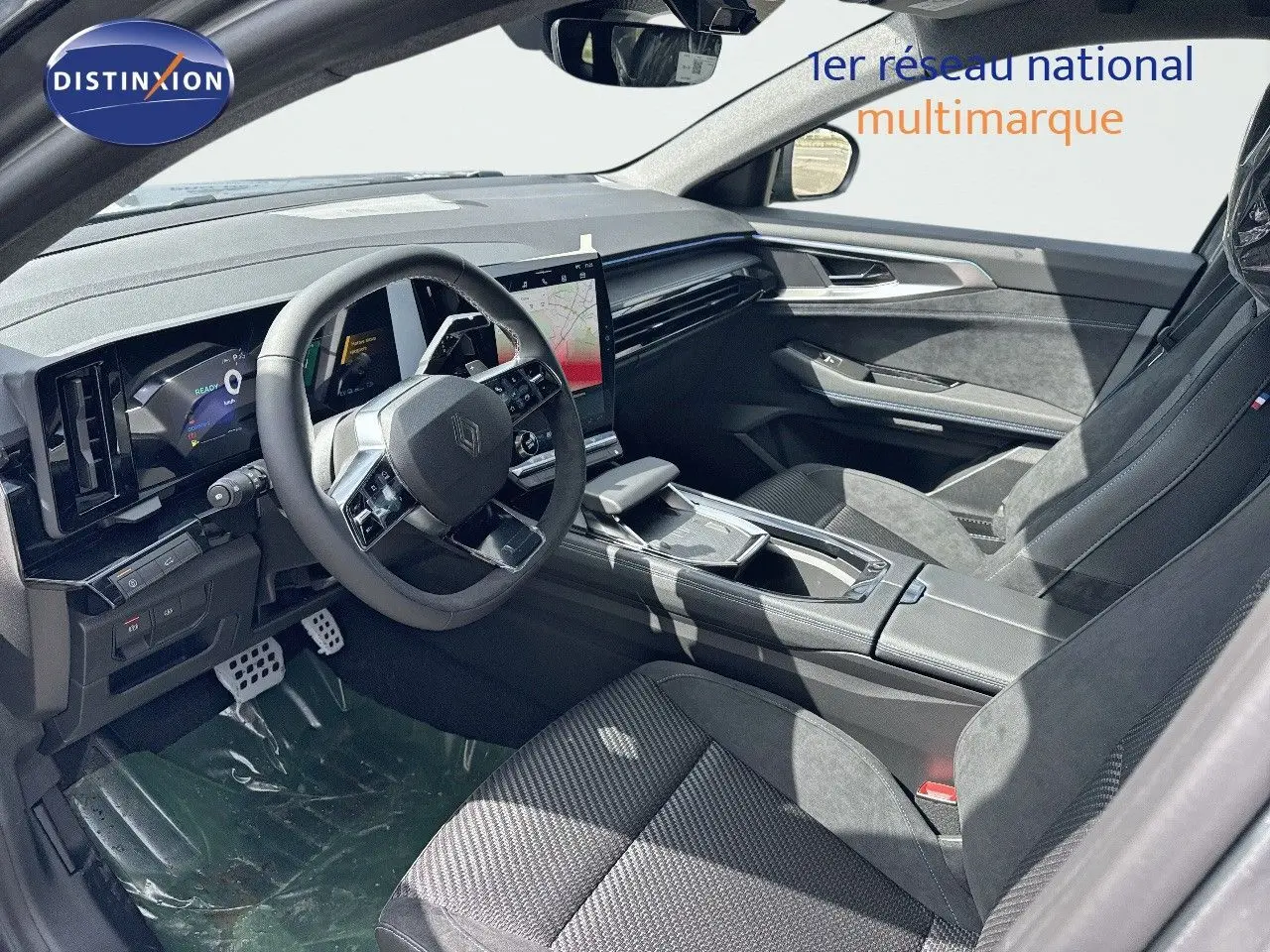 Intérieur du Renault Austral 2024 vu côté conducteur, sièges noirs et tableau de bord avec écran tactile vertical.