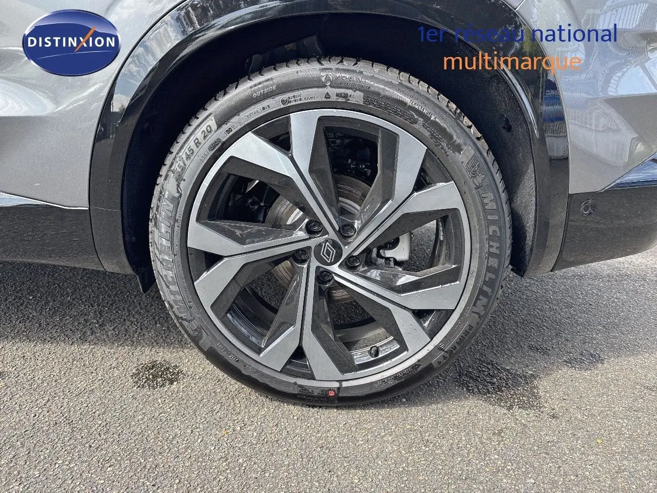 Gros plan sur la roue avant gauche du Renault Austral gris schiste métal avec jante alliage 20 pouces bicolore.