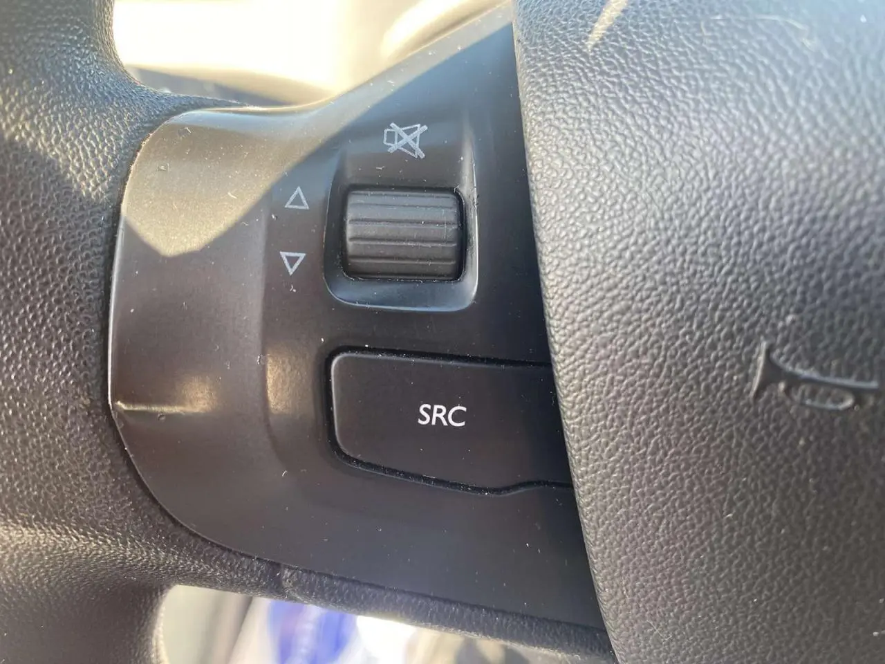 Gros plan sur les commandes audio au volant d'une Peugeot 208 noire, version Active+ GPS de 2016.