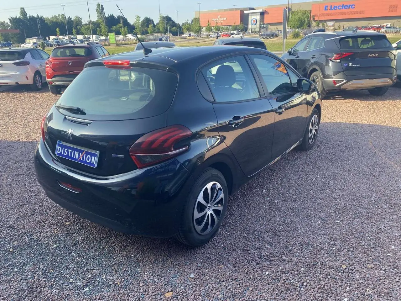 Peugeot 208 noire vue en 3/4 arrière droit, avec jantes acier 15 pouces et feux arrière distinctifs.