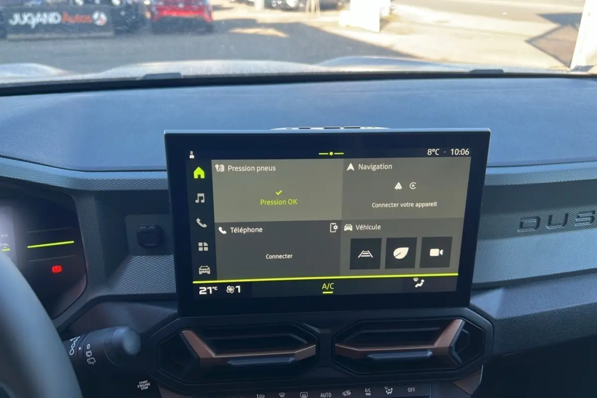 Écran tactile central du tableau de bord du Dacia Duster 2024 avec interface de contrôle et ventilation intégrée.