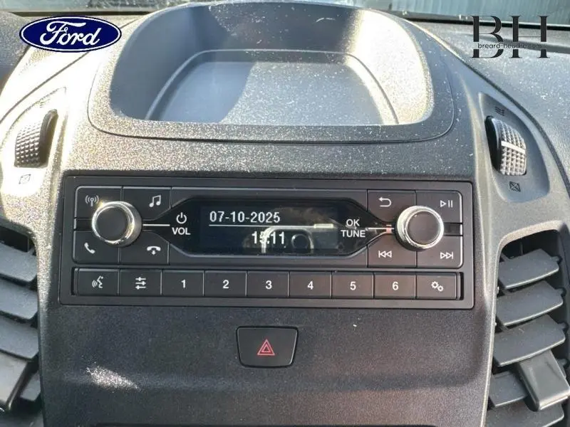 Vue rapprochée de la console centrale du Ford Transit Connect blanc glacier 2021, avec radio et commandes audio intégrées.