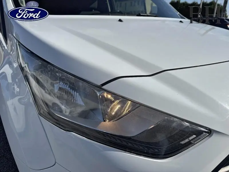 Gros plan sur le phare avant gauche du Ford Transit Connect blanc glacier, soulignant son design moderne et épuré.