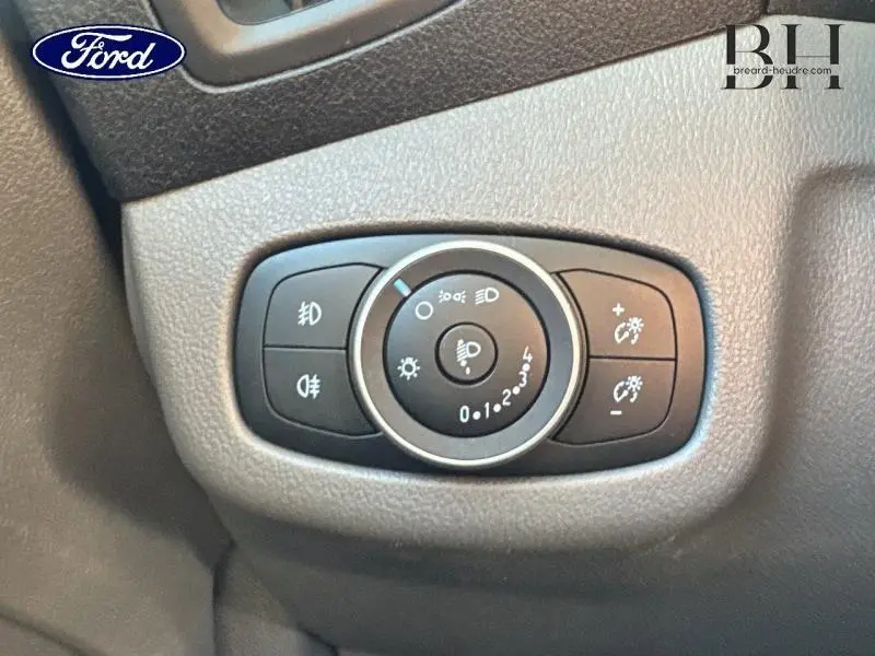 Gros plan sur les commandes d'éclairage du Ford Transit Connect blanc glacier, avec réglages des phares et feux antibrouillard visibles.