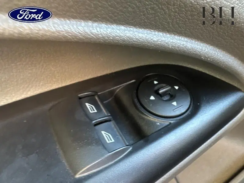 Gros plan sur les commandes de lève-vitres et réglage des rétroviseurs côté gauche du Ford Transit Connect blanc glacier 2021.