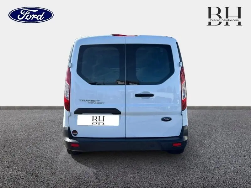 Vue arrière du Ford Transit Connect blanc glacier avec portes battantes et vitres teintées sur fond neutre.