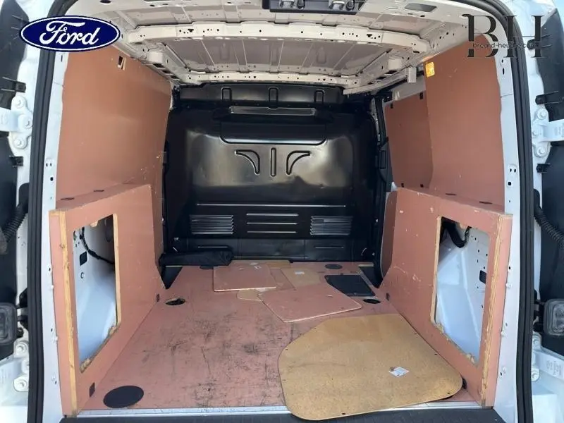 Vue arrière intérieure du Ford Transit Connect blanc glacier 2021 avec cloison complète tôlée et plancher usagé.