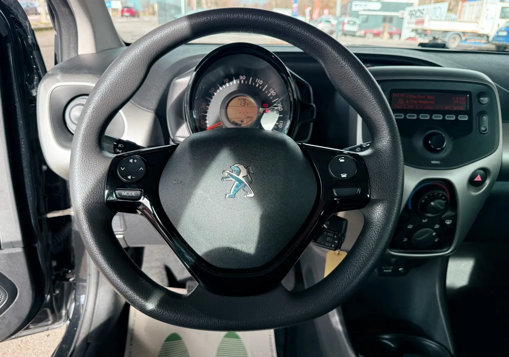 Vue centrée sur le volant noir de la Peugeot 108 2018 avec tableau de bord et console centrale en arrière-plan.