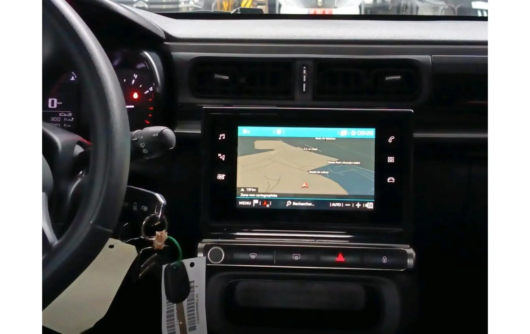 Vue intérieure centrée sur le tableau de bord et l’écran tactile du Citroën C3 Société blanc, avec volant à gauche.