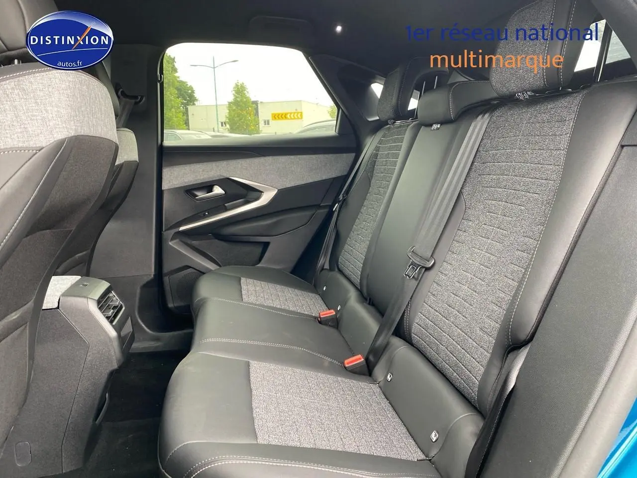 Vue côté droit de l’habitacle arrière du Peugeot 3008 bleu, montrant la banquette bicolore en tissu et cuir.