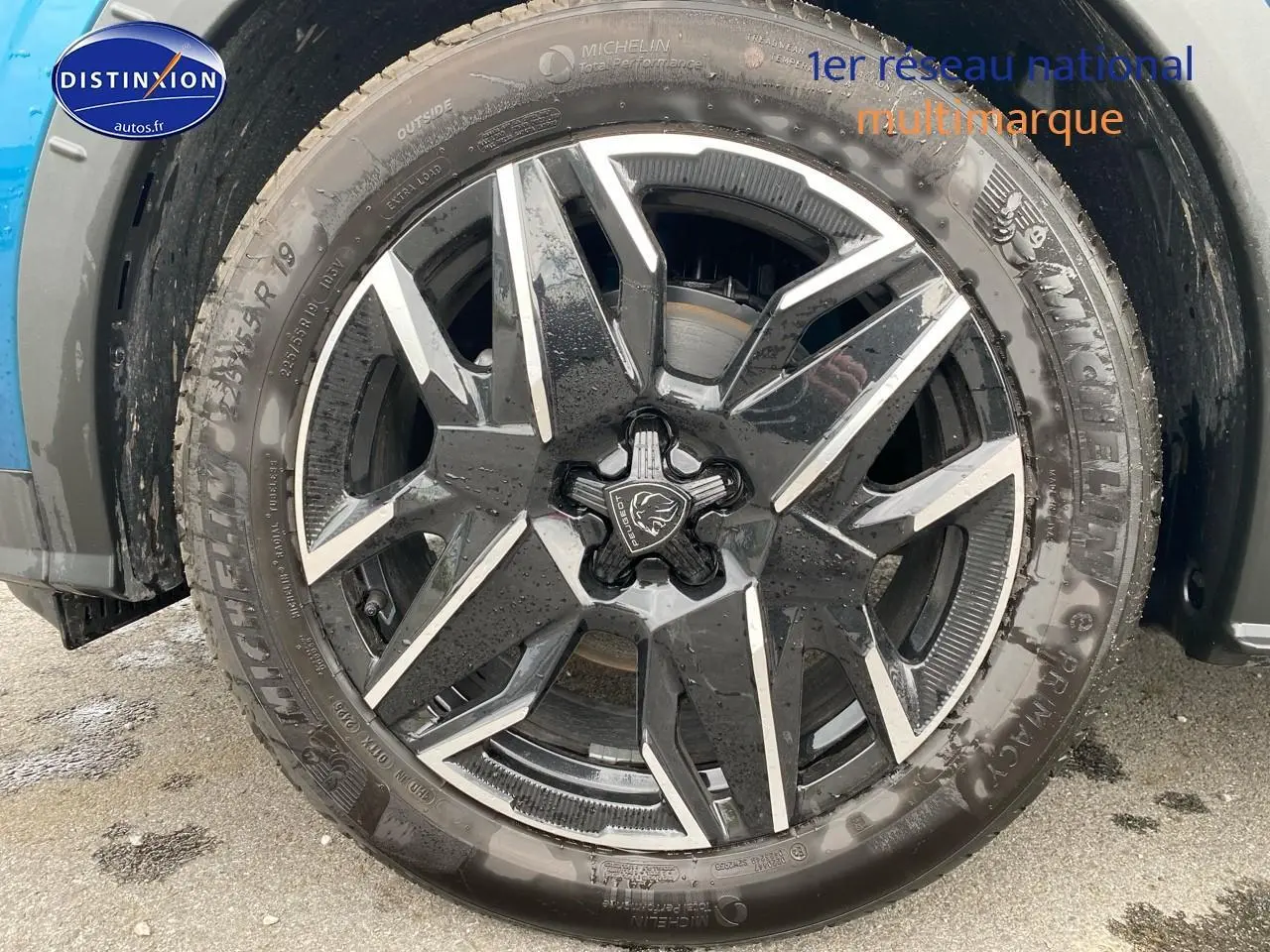 Gros plan sur la jante alu noire et argentée d’un Peugeot 3008 bleu, vue côté droit avec pneu Michelin.
