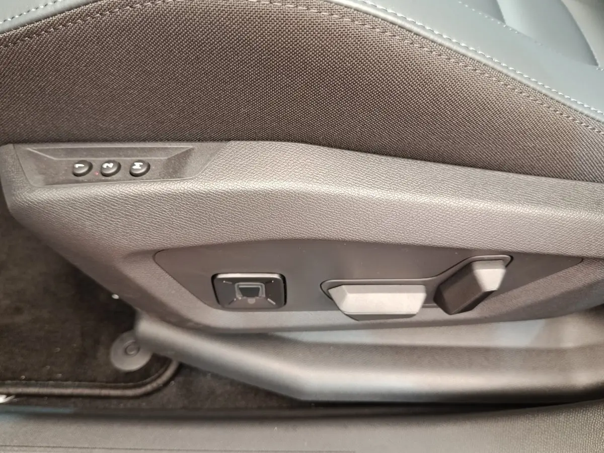 Détail des commandes de réglage électrique du siège avant côté conducteur du Citroën C5 hybride vert 2026.