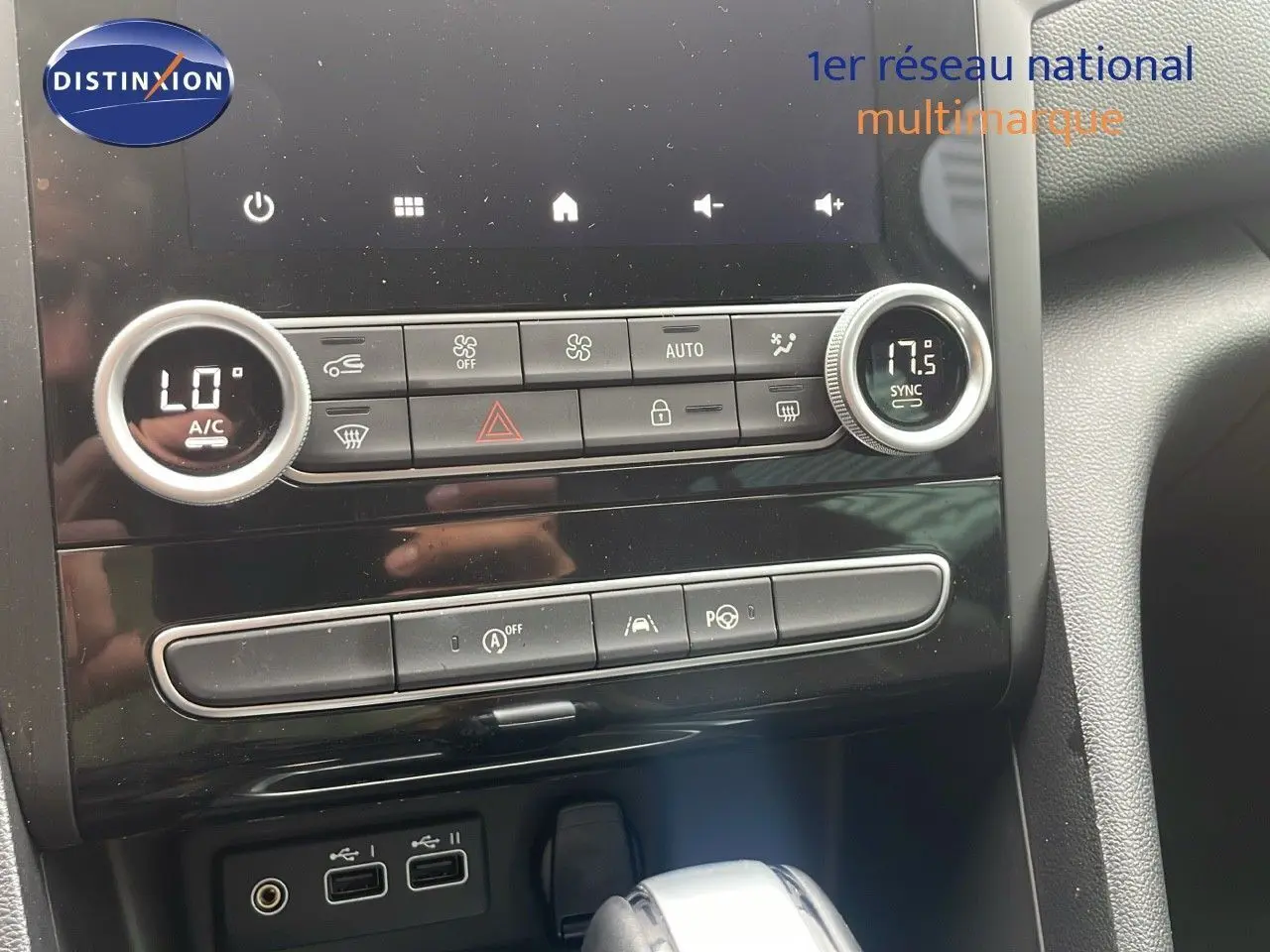 Gros plan sur la console centrale de la Renault Mégane Break 2024, avec commandes climatisation et boîte automatique visible.