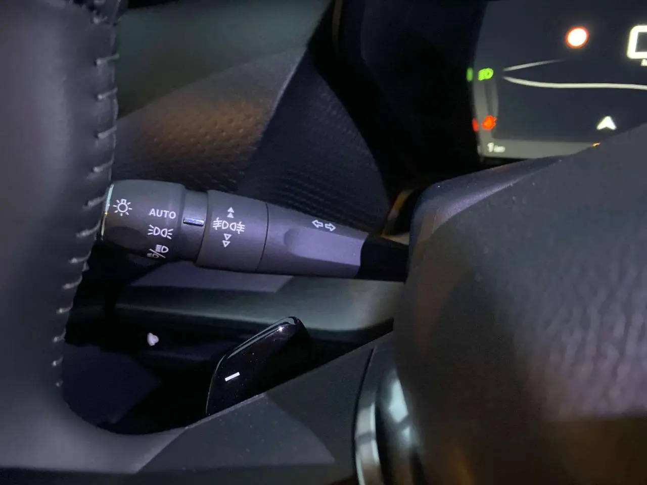 Détail du commodo d'éclairage à gauche du volant du Citroën C5 X gris Artense métal 2023.