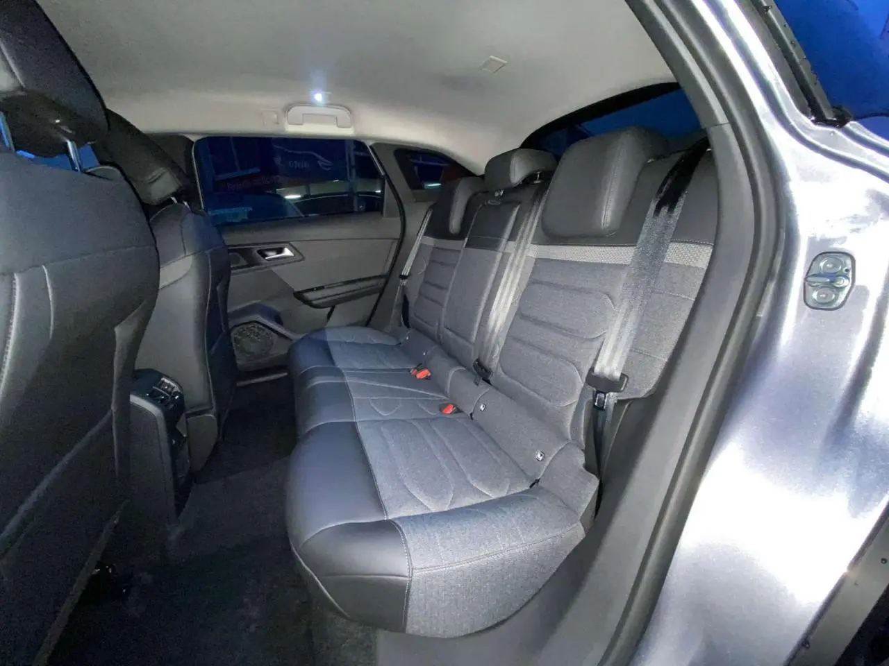 Vue intérieure arrière droite sur les sièges gris tissu et cuir du Citroën C5 X 2023 gris Artense métallisé.