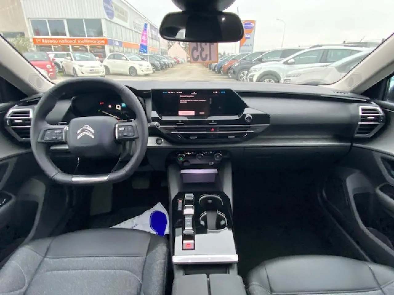 Vue intérieure avant du Citroën C5 X 2023, tableau de bord moderne avec écran tactile et volant multifonction noir.