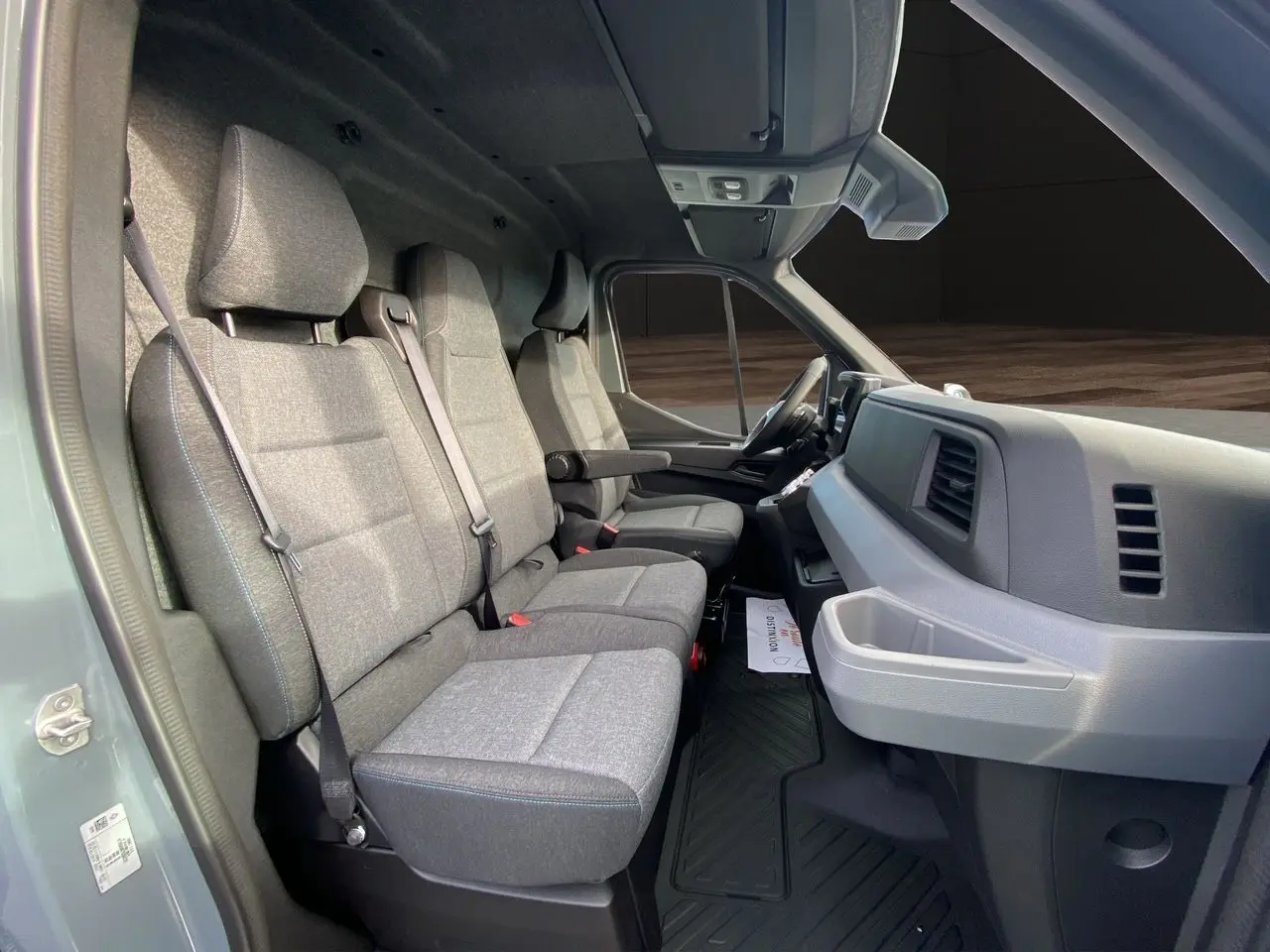 Vue intérieure côté gauche du Renault Master 2025 gris urbain, montrant les sièges avant et le tableau de bord.