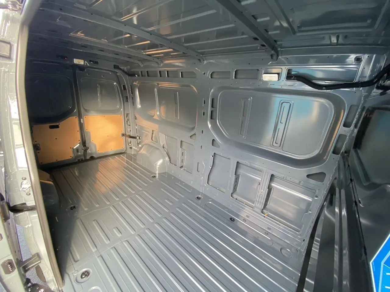 Vue intérieure arrière du Renault Master gris urbain 2025, montrant la grande zone de chargement métallique vide.