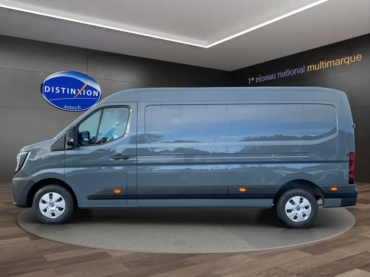 Profil droit du Renault Master gris urbain 2025 en version fourgon long avec marquages latéraux orange.