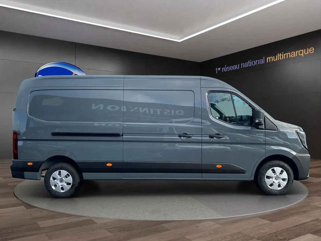 Vue latérale droite d’un Renault Master 2025 gris urbain avec jantes acier et feux latéraux orange en showroom.