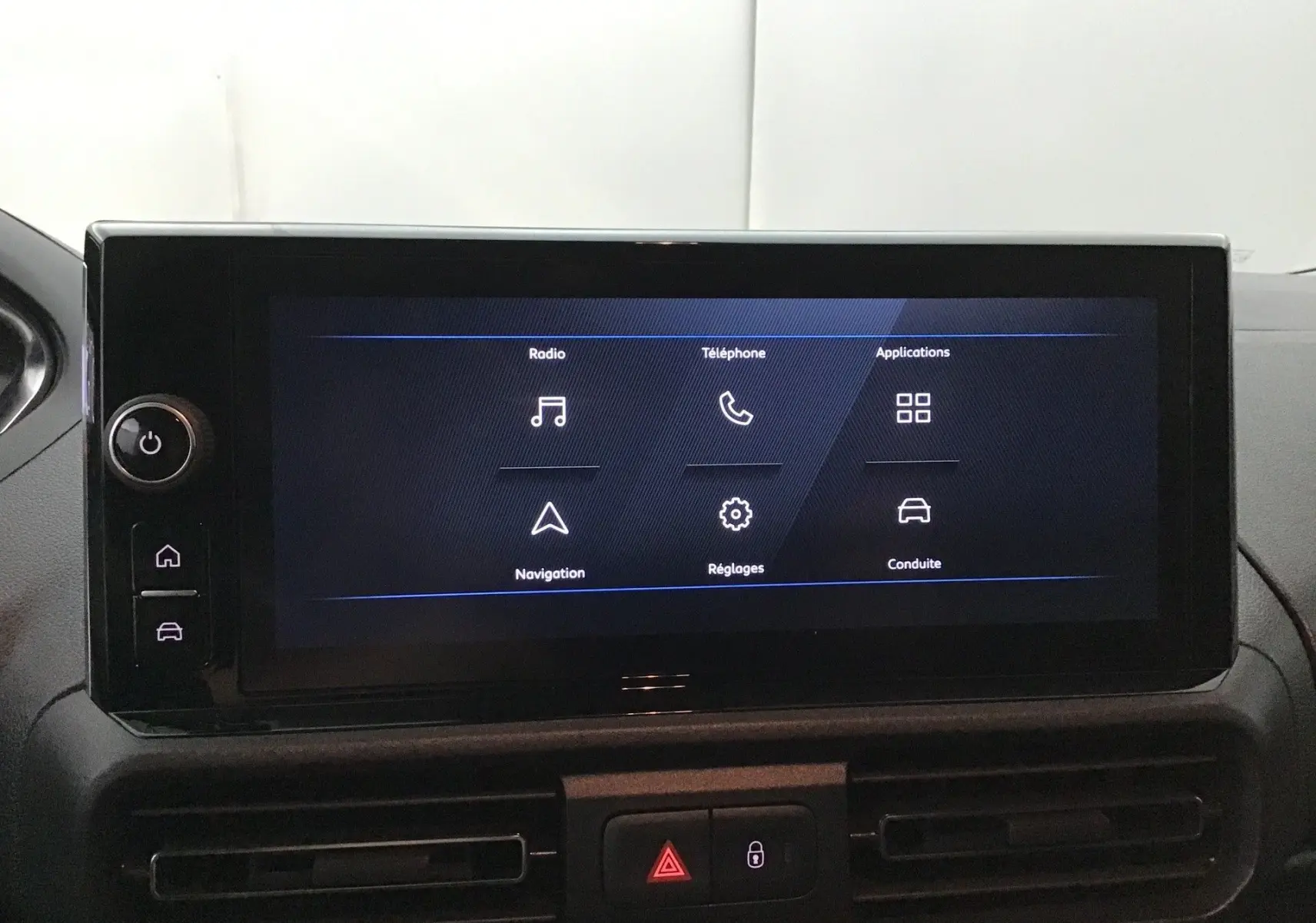 Écran tactile central du tableau de bord du Peugeot Partner 2025 affichant les options radio, téléphone, navigation et réglages.