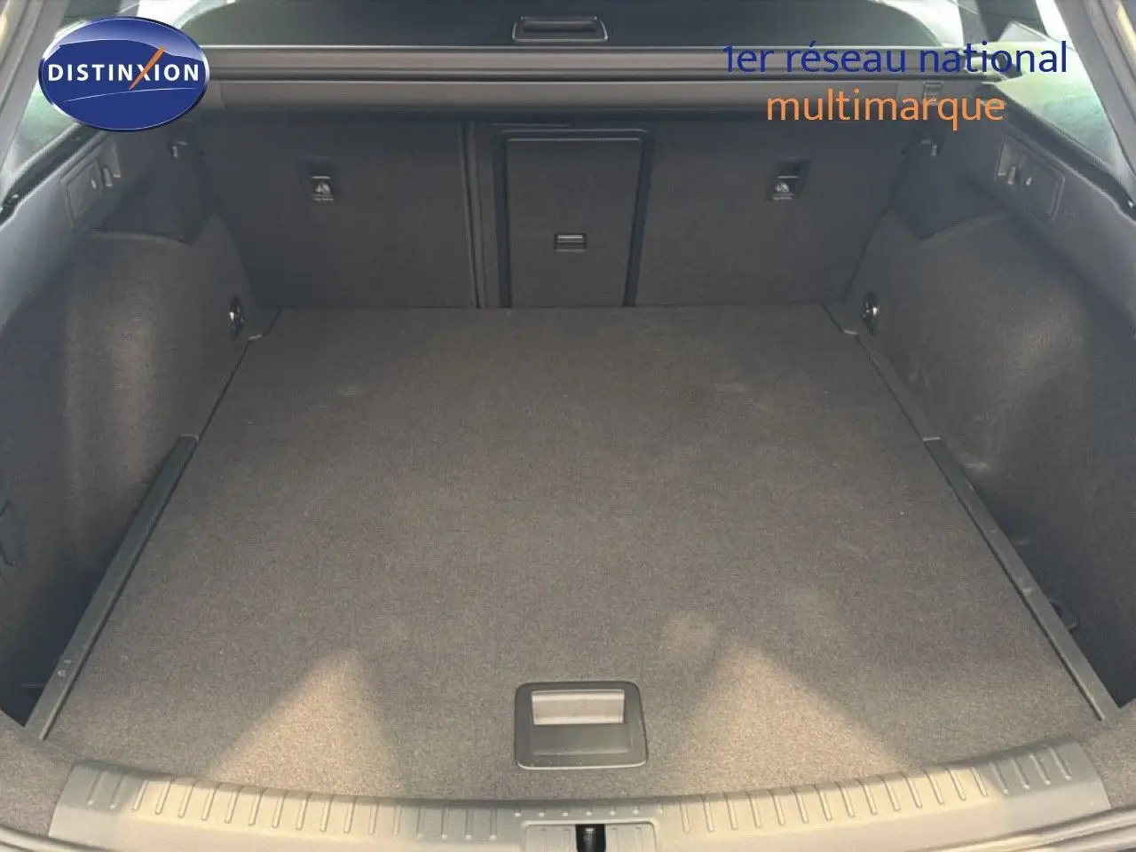 Vue du coffre spacieux et plat de la CUPRA LEON ST 1.5 eTSI en gris magnétique métal, intérieur sombre et propre.