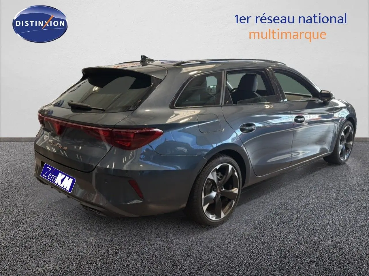 Vue 3/4 arrière droite d'une CUPRA LEON ST gris magnétique métallisé avec jantes bi-ton et feux arrière allongés.