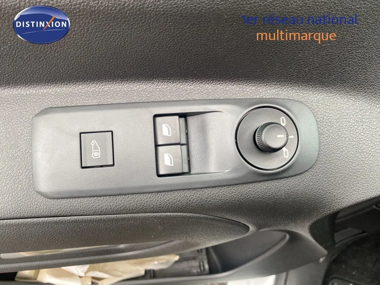 Vue rapprochée des commandes de réglage des rétroviseurs et des vitres sur la porte côté gauche du Citroën Berlingo Fourgon blanc 2025.