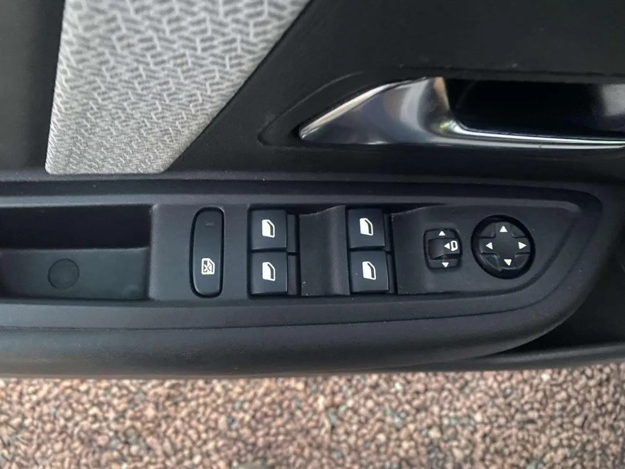 Panneau de commandes des vitres et rétroviseurs côté conducteur dans une Citroën C4 blanche de 2021.