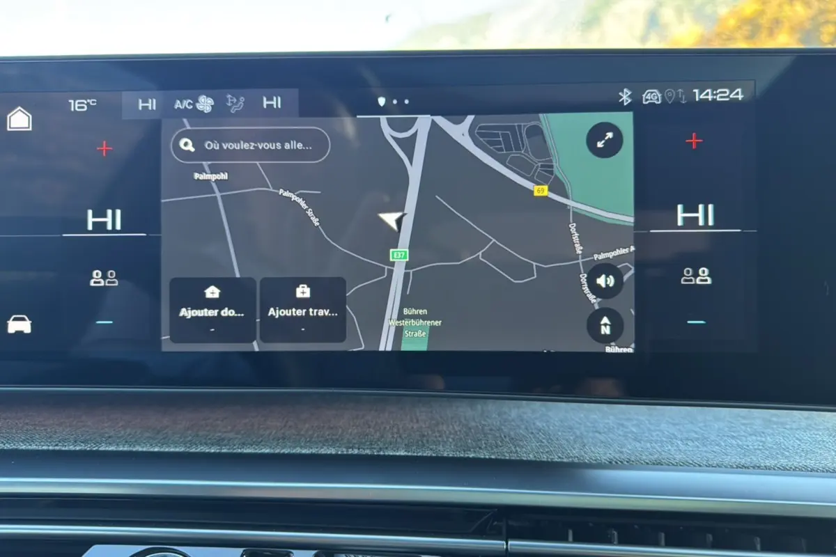 Écran tactile du système de navigation du Peugeot 3008 Hybrid 2024, affichant une carte et les commandes climatisation.
