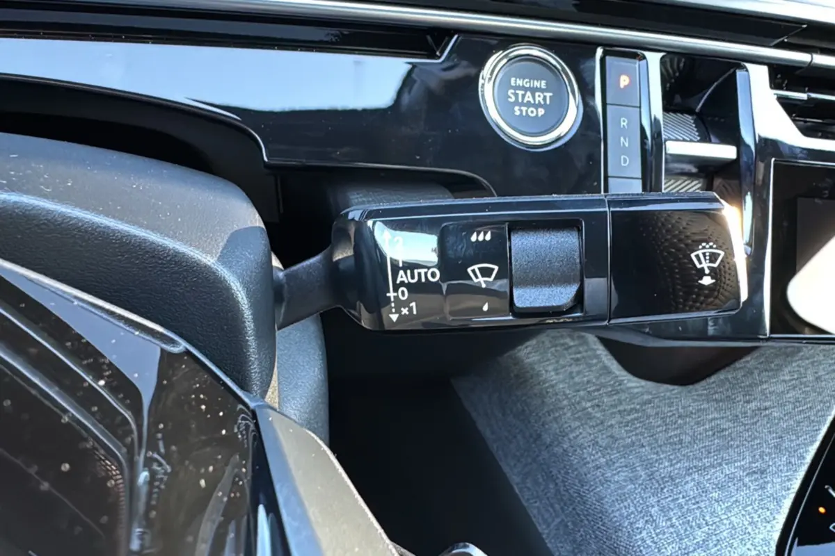 Gros plan sur la commande d'essuie-glace et le bouton start/stop du tableau de bord du Peugeot 3008 Hybrid 2024.