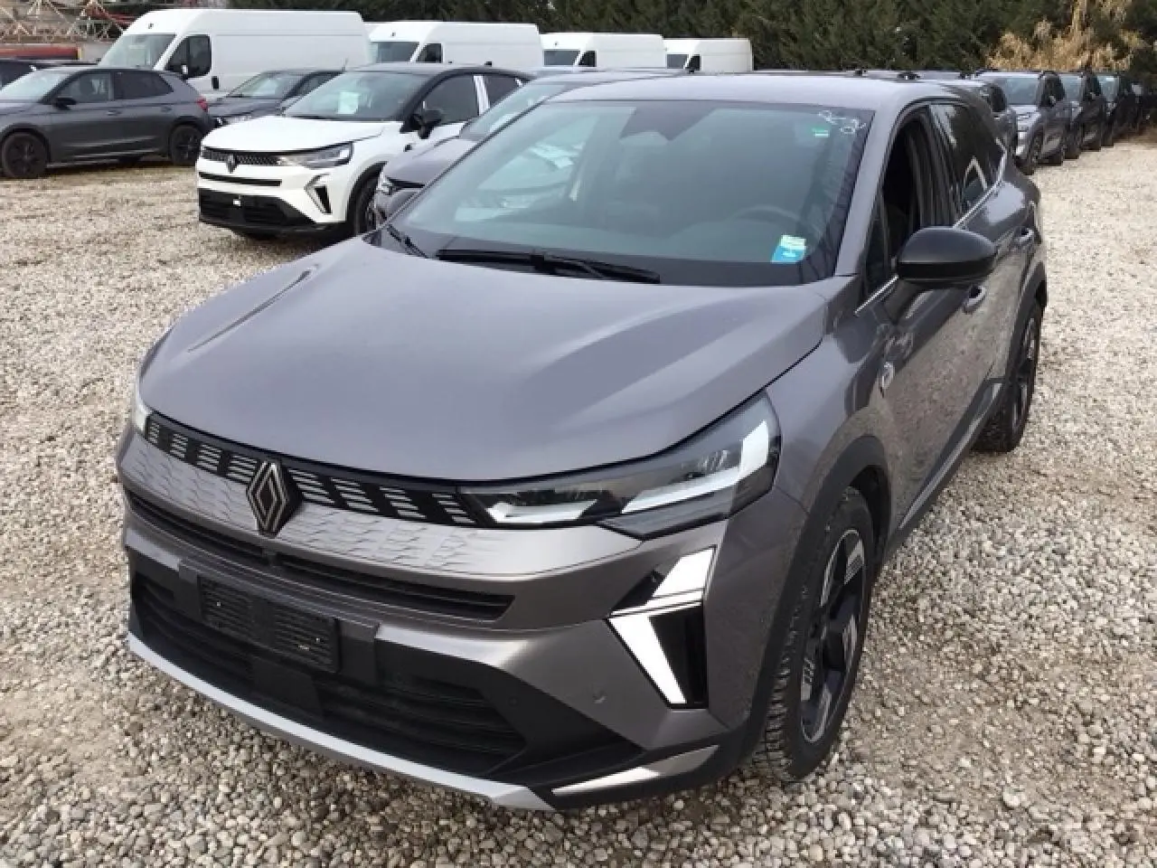 Vue 3/4 avant d'une Renault SYMBIOZ gris Cassiopée avec calandre noire et jantes 18 pouces au design moderne.